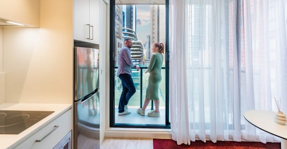 a man and a woman are standing in a glass door