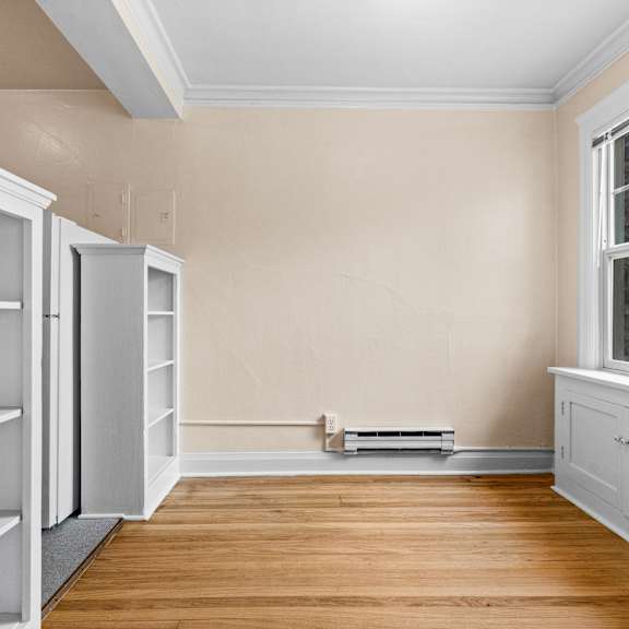 a kitchen with a stove and shelves on the wall