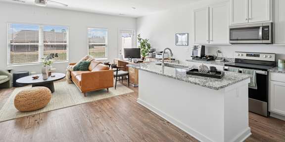 A living room with a white couch, a coffee table, and a ceiling fan.
