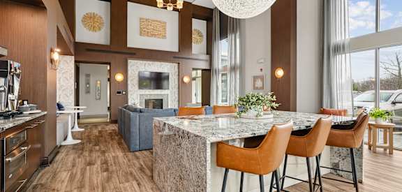 A modern kitchen with a marble island and wooden floors.