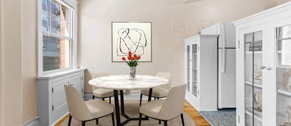 A dining room with a white table and chairs.