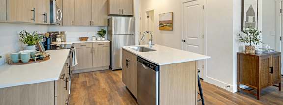 a large kitchen with white counter tops and stainless steel appliances