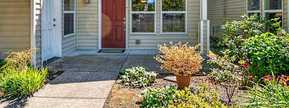 A house with a red door and a small front yard.