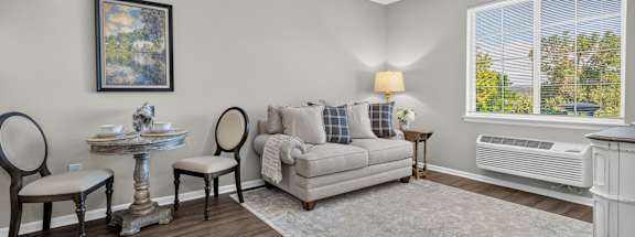 A living room with a couch, chairs, and a table.