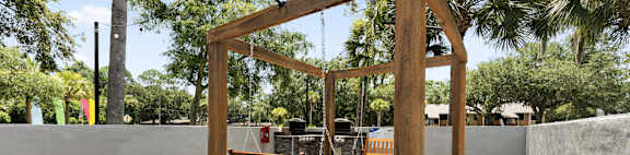 a swing bench in the backyard of a house