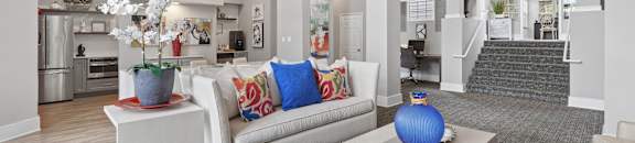 A modern living room with a white couch and a television mounted on the wall.