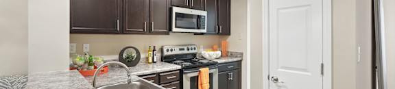A kitchen with brown cabinets and a white door.