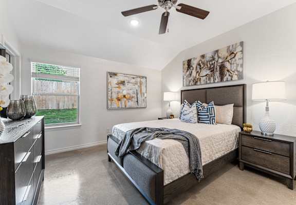 the master bedroom in a new home with a ceiling fan
