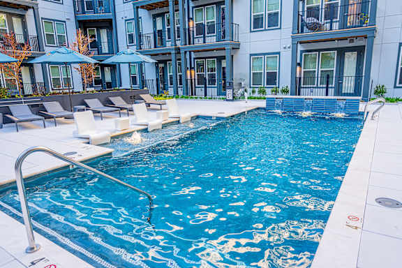 A swimming pool with a metal ladder and a white bench.