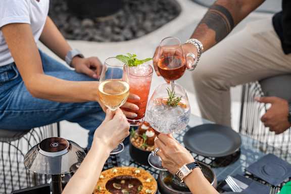 A group of people toasting with drinks at a table.