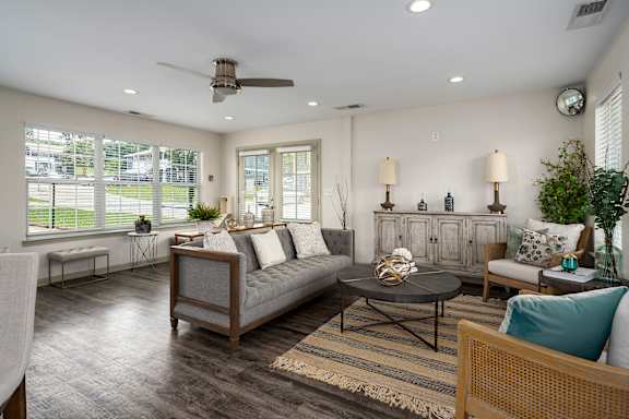 A living room with a grey couch and a wooden coffee table.
