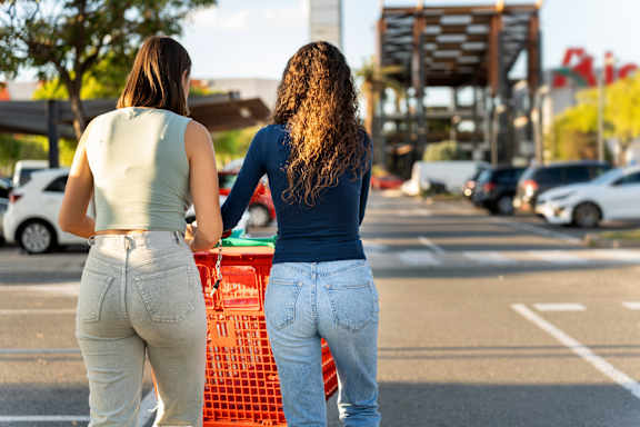Two women are shopping in a parking lot.