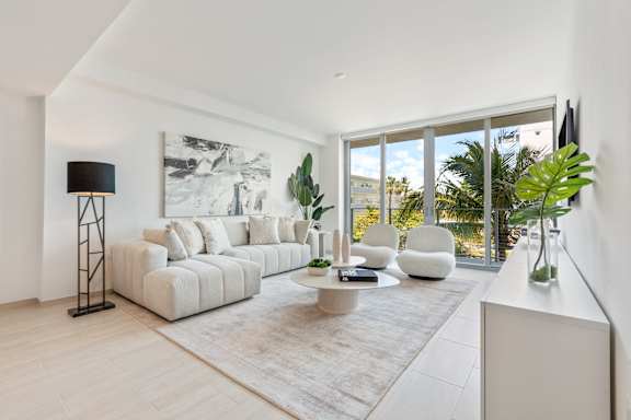 A modern living room with a large white sofa and a floor lamp.