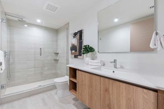 A modern bathroom with a walk-in shower and a double sink vanity.