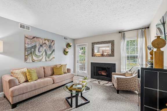 A living room with a fireplace and a painting on the wall.