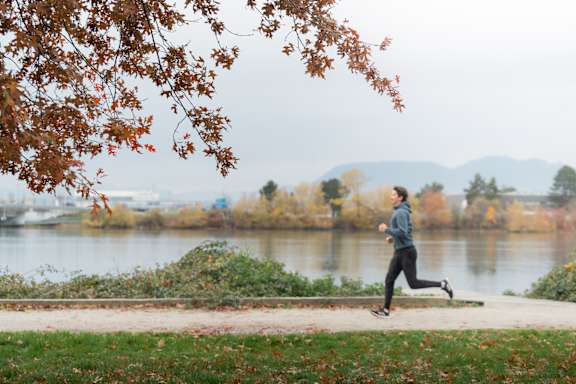 A person running on a path near a lake.
