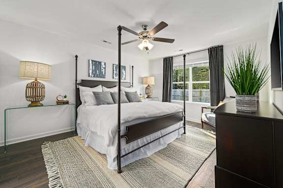 A bedroom with a large bed and a ceiling fan.