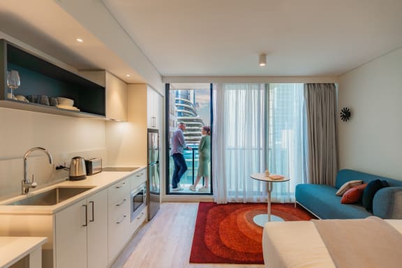 a kitchen and living room with a sliding glass door to a balcony