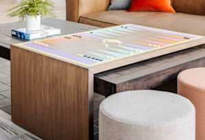 A wooden table with a game on it and a potted plant on the side.
