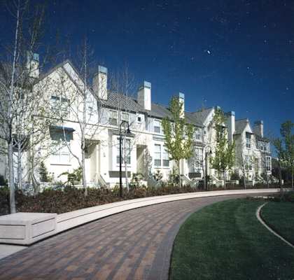 a large white house with a sidewalk in front of it