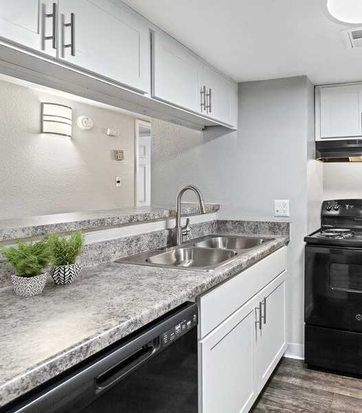 A modern kitchen with black appliances and white cabinets.