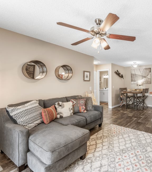 a living room with a couch and a ceiling fan