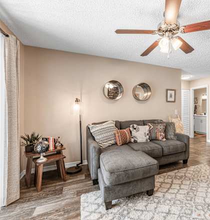 A living room with a grey couch and a wooden coffee table. at Epic Apartments , Daytona Beach, FL, 32114