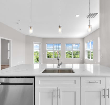 A modern kitchen with white cabinets and a large island.