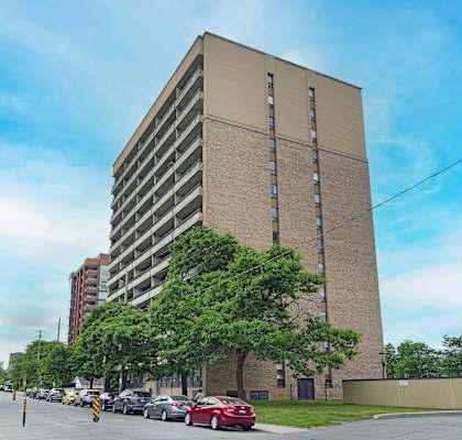 A tall building with a parking lot in front of it.