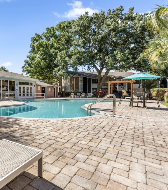 a swimming pool in front of a house with a resort style pool