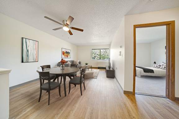 Open concept living and dining room with wood style flooring at Edinlake Apartments, Edinboro, PA