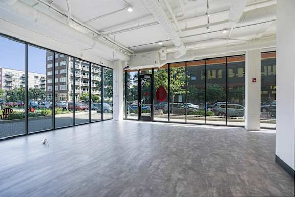 A large empty room with a wooden floor and white walls.