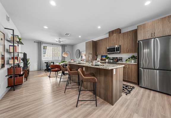A modern kitchen with a bar area and a refrigerator.