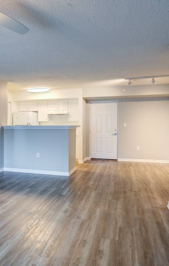 A room with wooden flooring and white walls.