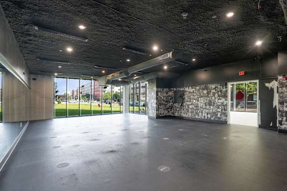A spacious room with a grey floor and a wall covered in black and white photos.