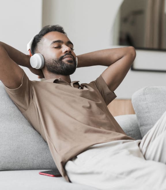 a man is laying on a couch with headphones on his head