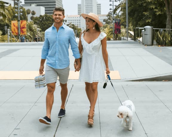 A man and woman walking a dog on a sidewalk. at The Palms 1101, Columbia, 29201
