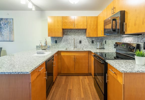 A kitchen with wooden cabinets and granite countertops.