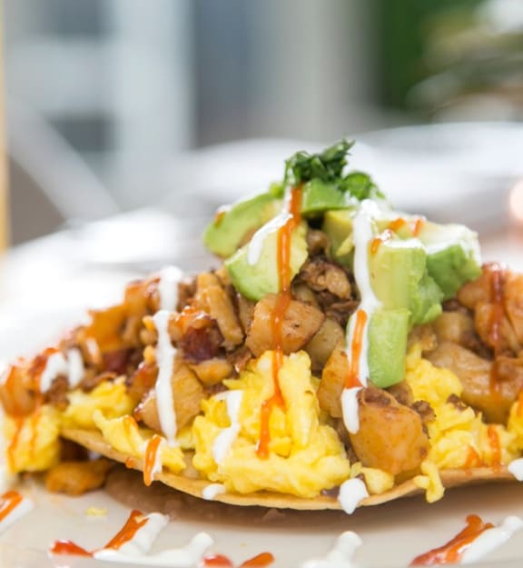 a taco with scrambled eggs and avocado on a plate