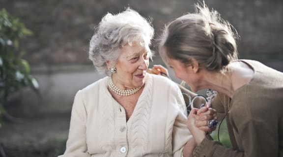 Elderly woman and young woman talking