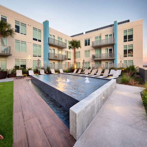 Fountain pond at Lake Nona Pixon with lounge chairs on the Amenity Deck at dusk