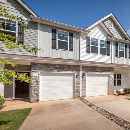A house with a garage and a driveway in front.