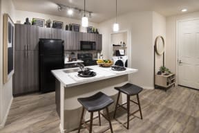 a kitchen with a large island and a black refrigerator