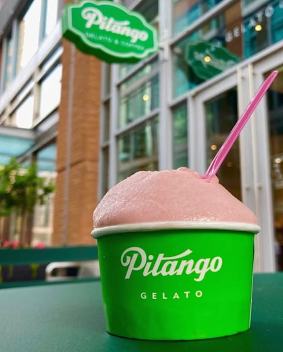 A green container of Pilango gelato with a pink spoon in it.