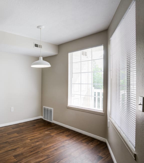 an empty living room with wood flooring and a large window
