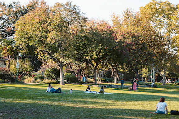 A park with people sitting on the grass.