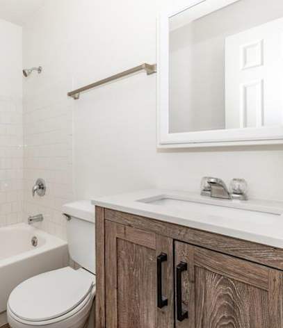 A white bathroom with a toilet, sink, and tub.