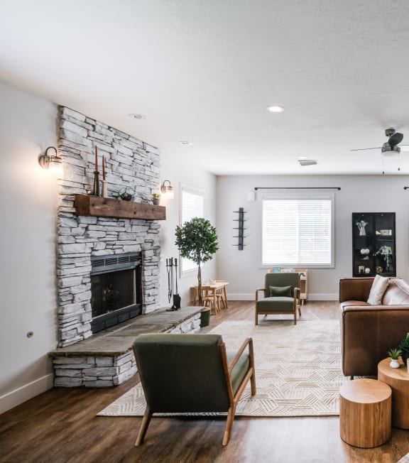 the living room of a house with a fireplace and a table and chairs