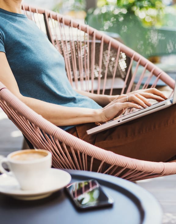 a woman sitting in a chair using a laptop computer
