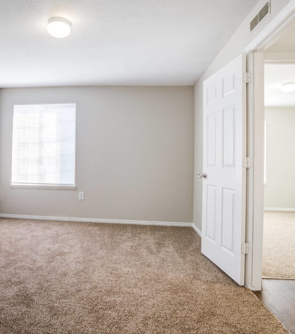 an empty room with a white door and a window